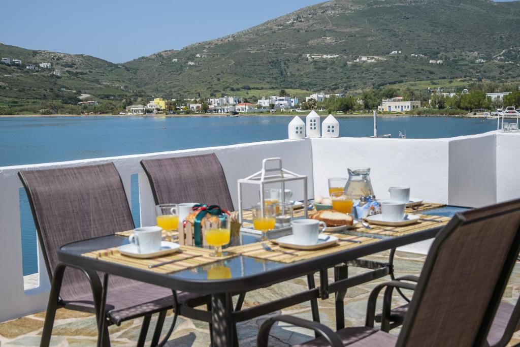 a table with glasses of orange juice on a balcony at The Veranda of Gavrion-Exclusive, Centrally located with Seaview in Gavrio