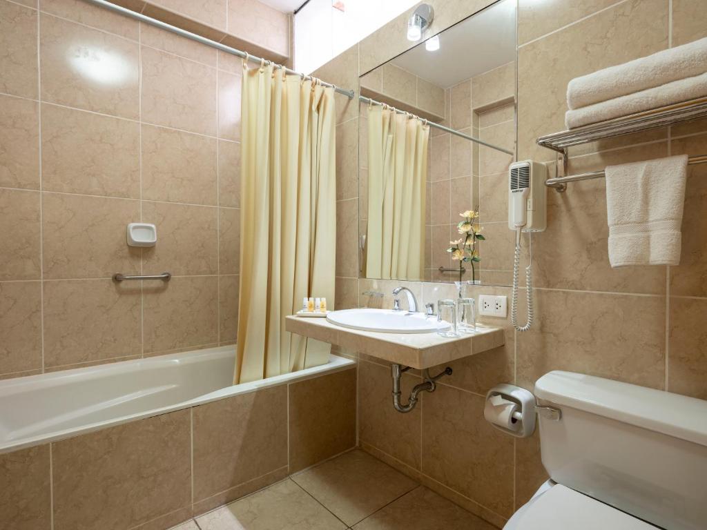 bagno con lavandino, vasca e servizi igienici di Qorianka Hotel a Lima