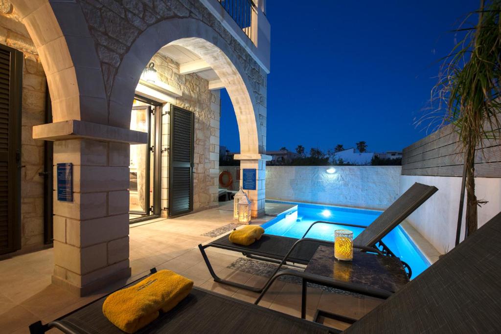 a swimming pool in a villa at night at Villa Christy in Stalos