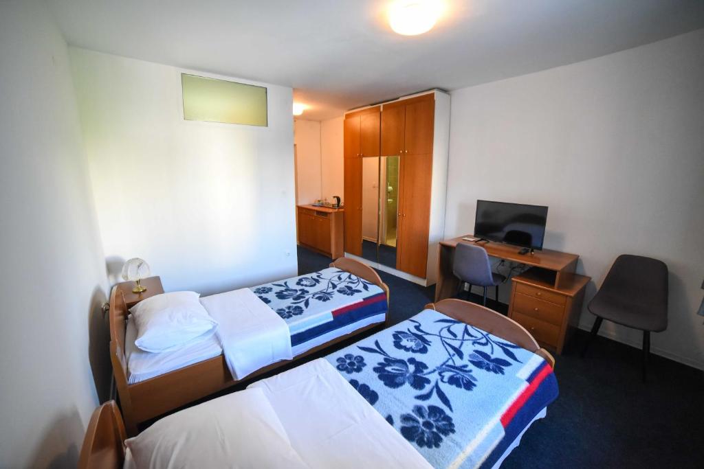 um quarto de hotel com duas camas e uma secretária em Guest House Duje em Split