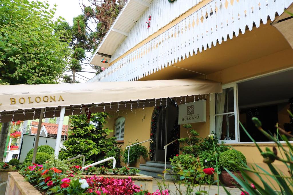 an awning on a house with flowers and plants at Hotel Bologna in Campos do Jordão