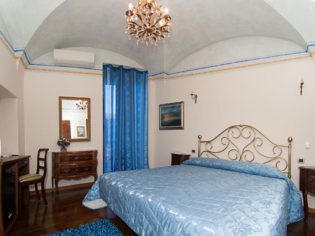 タルクイーニアにあるPalazzo Rosatiのベッドルーム(青いベッド1台、シャンデリア付)