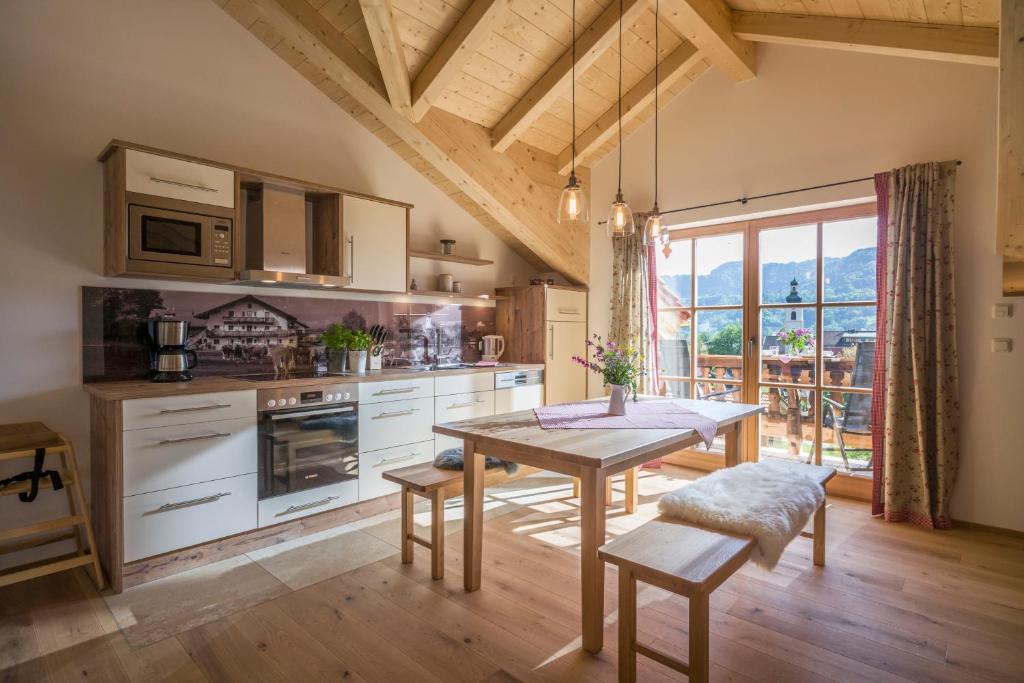 a kitchen with a table and a large window at Lainthalerhof in Oberaudorf
