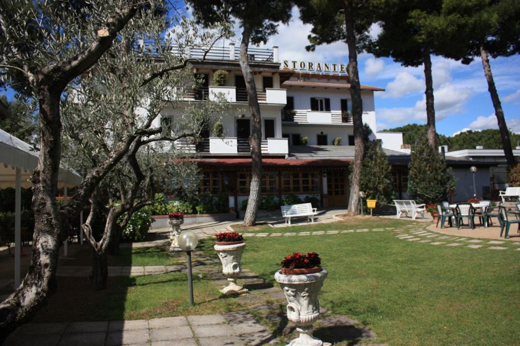a building with two vases of flowers in a yard at Hotel Ristorante La Bilancia in Loreto Aprutino
