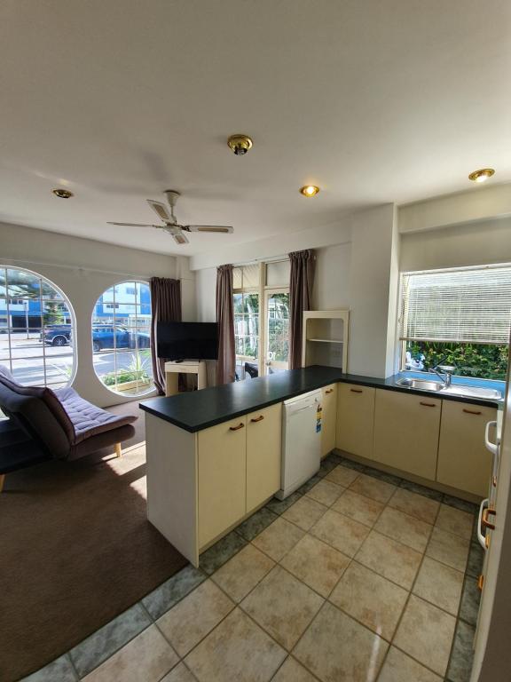 a kitchen with a counter top and a living room at U Studios Paraparaumu Beach in Paraparaumu Beach