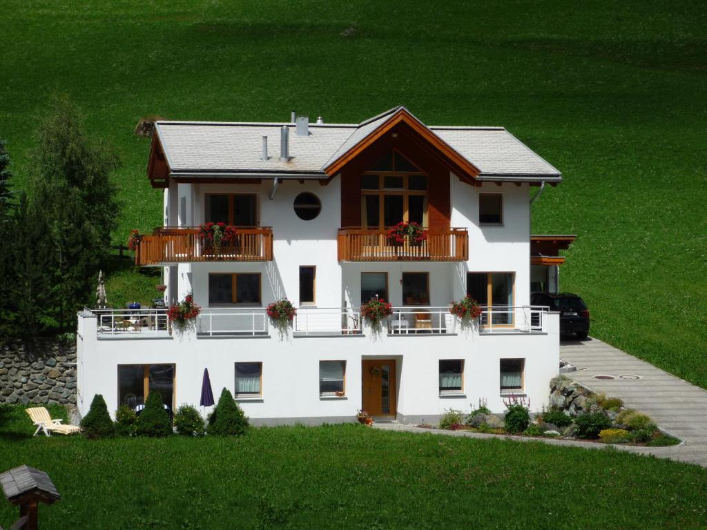 Cette grande maison blanche dispose d'une terrasse couverte et d'un balcon. dans l'établissement Apartment MEZPRA, à Samnaun