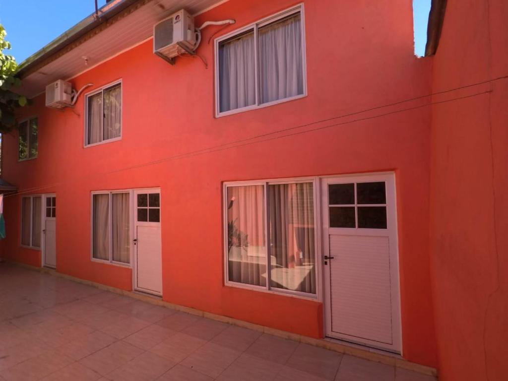 een rood gebouw met witte deuren en ramen bij Apart Morel in Puerto Iguazú