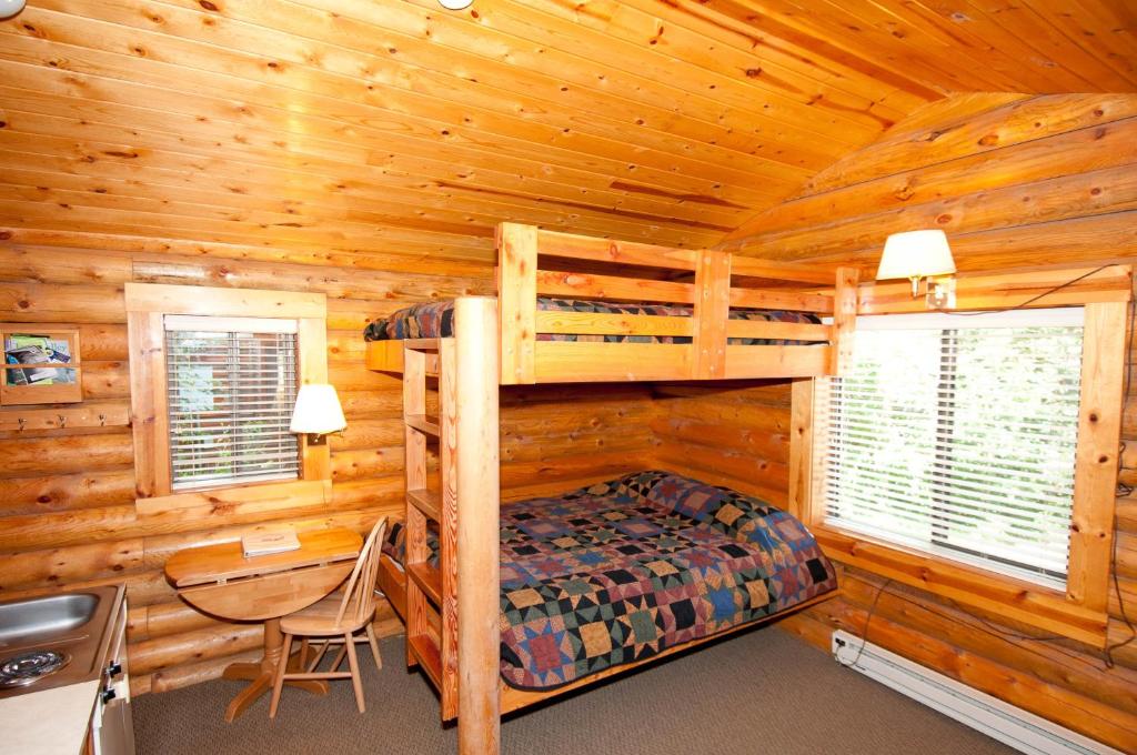 a bedroom with a bunk bed in a log cabin at Teton Valley Cabins in Driggs