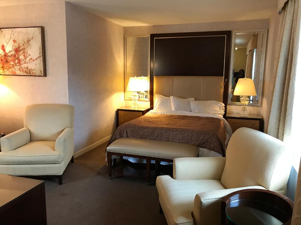 pokój hotelowy z łóżkiem i 2 krzesłami w obiekcie Cardinal Court Motel w mieście Saint Thomas