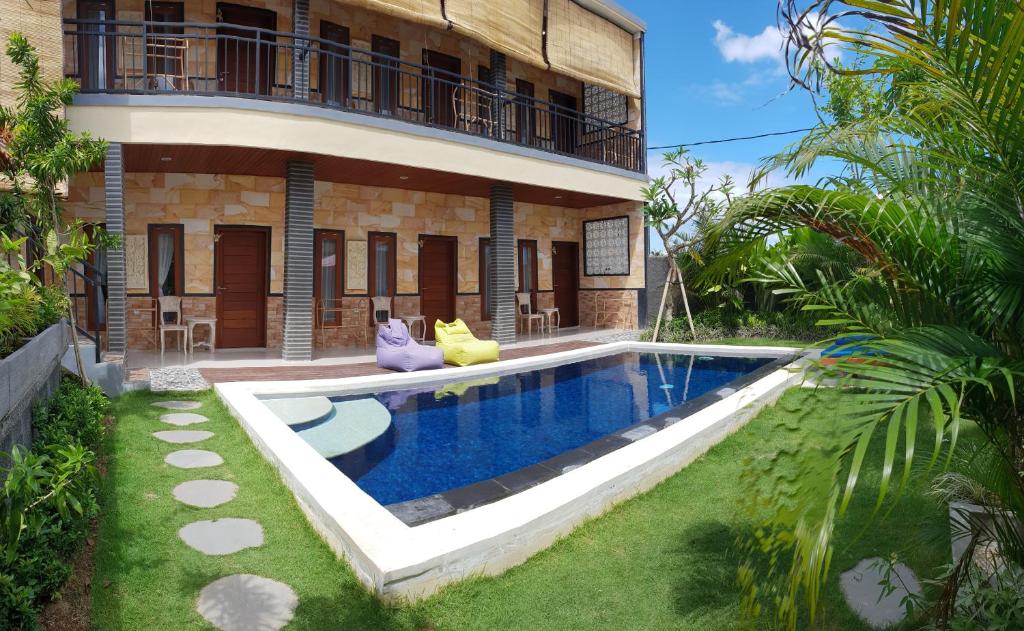 une villa avec une piscine en face d'un bâtiment dans l'établissement Sun Homestay Canggu, à Canggu