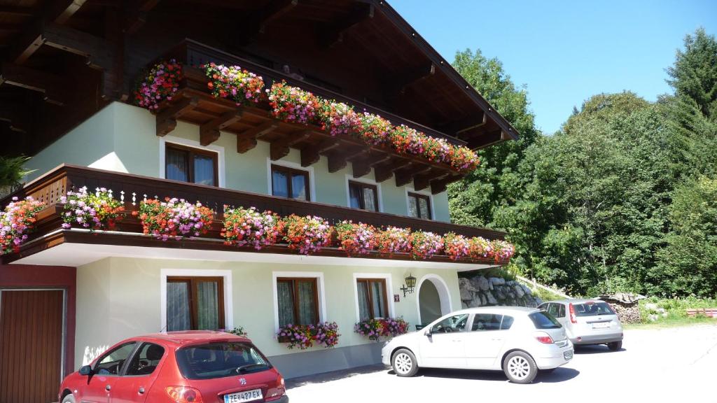 a building with a bunch of flowers on a balcony at Haus Rieder Georg in Maria Alm am Steinernen Meer
