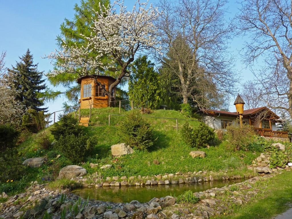 a house on top of a hill next to a river at Harzer Feriengarten 5***** in Bad Suderode