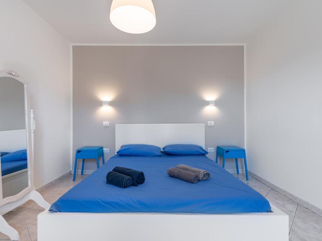 1 dormitorio con 1 cama azul y sillas azules en Spritz Bed & Breakfast, en Quartu SantʼElena