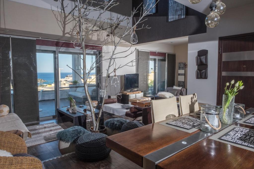 a living room with a table and a view of the ocean at Relux Suite in Agios Nikolaos