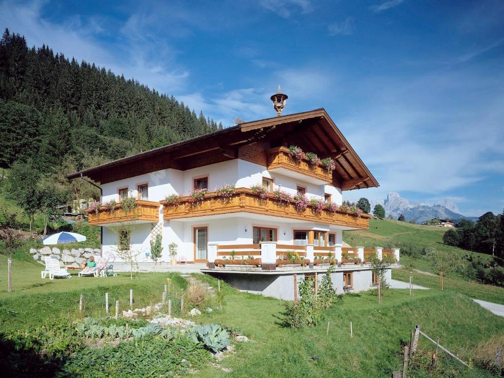 ein großes Haus auf einem Hügel mit einem Grasfeld in der Unterkunft Ferienhaus Rosi in Sankt Martin am Tennengebirge