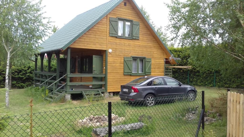 a small house with a car parked in front of it at Domek "U Magdy" in Sasino