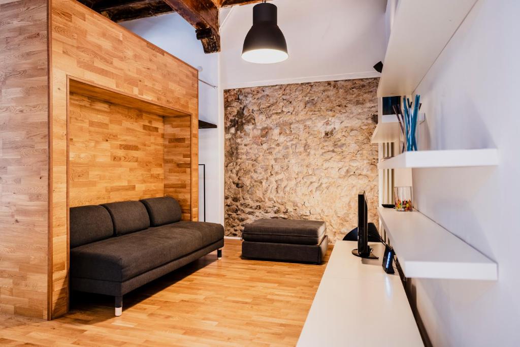 a living room with a couch and a brick wall at Casa Romeo in Cuneo