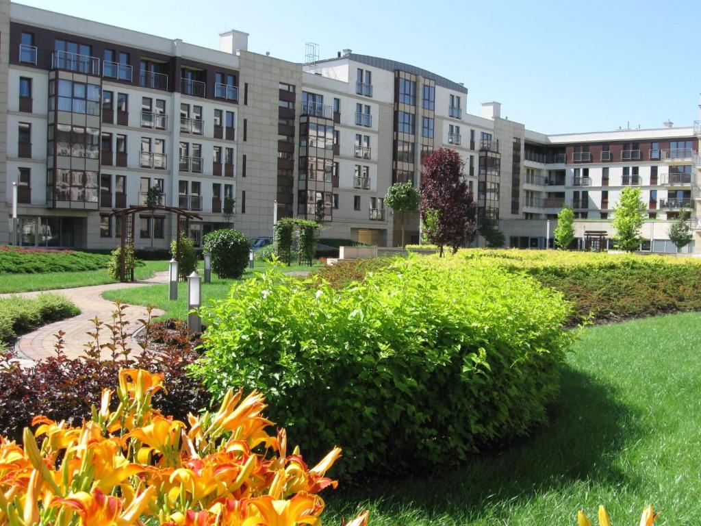 - une vue sur un bâtiment depuis un parc avec des buissons dans l'établissement Garden Corner, à Cracovie