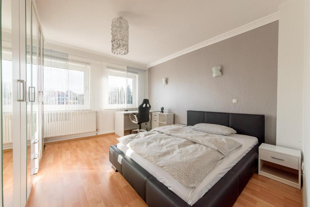 een slaapkamer met een groot bed en een bureau bij Private Apartment in Ronnenberg