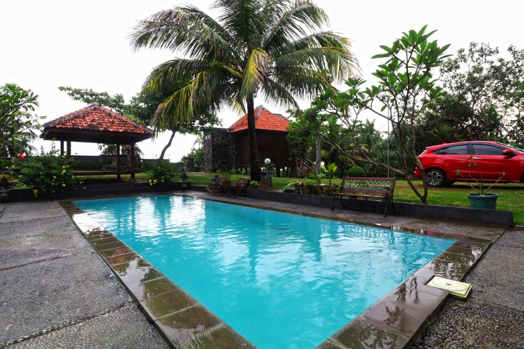 a swimming pool in front of a house with a car at Negla Beach Villa in Godog