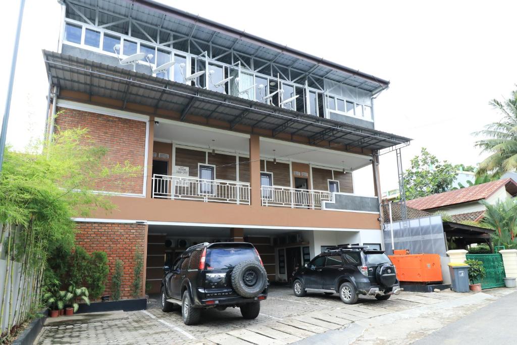 un edificio con dos coches estacionados frente a él en Hotel Celia, en Samarinda