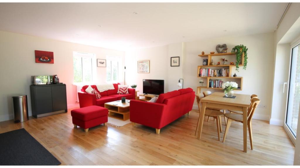 sala de estar con sillas rojas y mesa en ★ Luxury Oxford Apartment ★ Sleeps 4, Free Parking, en Oxford