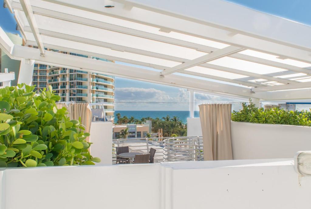 Penthouse De Soleil South Beach - on Ocean Drive Miami Beach في ميامي بيتش: بريقولا أبيض على شرفة تطل على المحيط