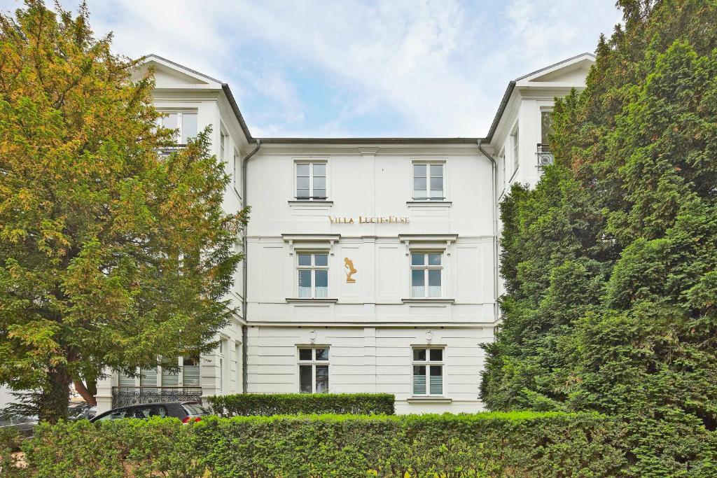Un edificio blanco con un cartel en él. en Villa Lucie Else Whg 04 Backbord, en Heringsdorf