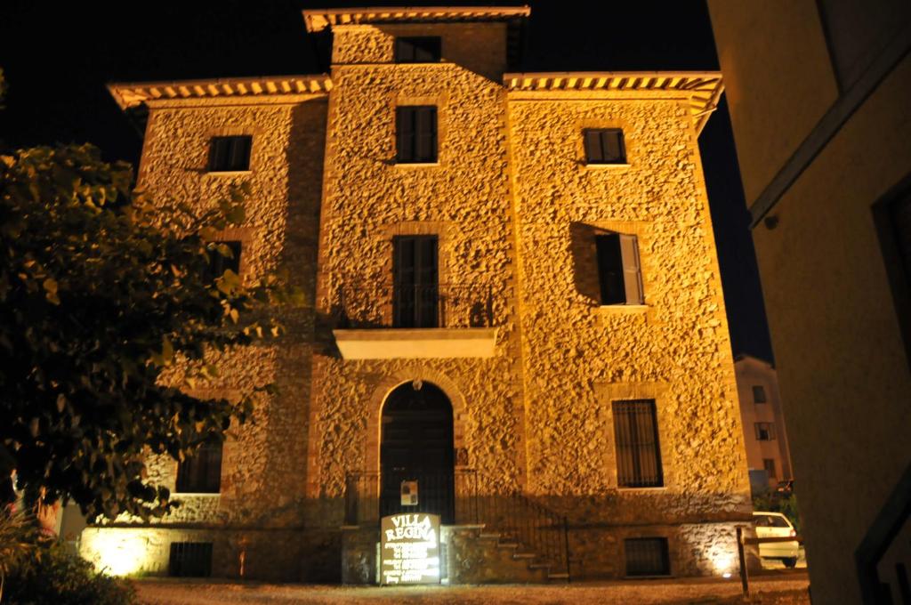 un antiguo edificio de piedra por la noche con luces en Villa Regina en Amelia
