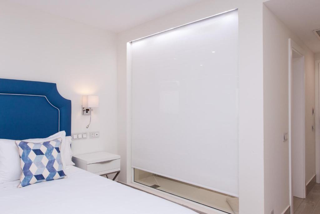a bedroom with a mirror next to a bed at Hotel Boutique TAO Caleta Mar in Corralejo