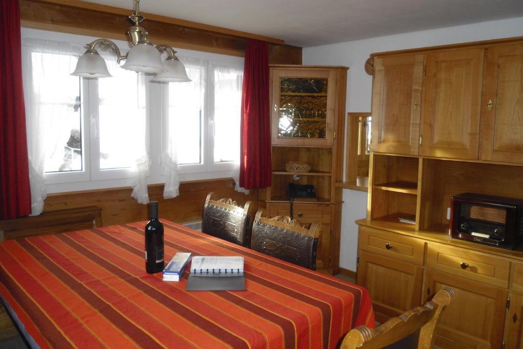 a dining room table with a bottle of wine on it at Chalet Grazia in Riederalp