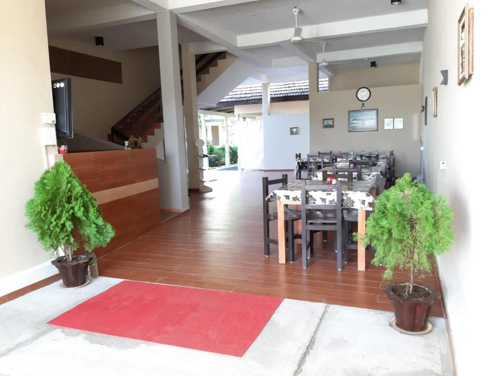 a dining room with a table and chairs and a red rug at Royal Point Arugambay in Arugam Bay
