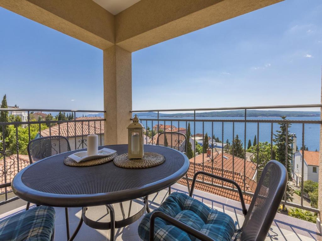 einen Tisch und Stühle auf einem Balkon mit Meerblick in der Unterkunft BRUNO in Crikvenica