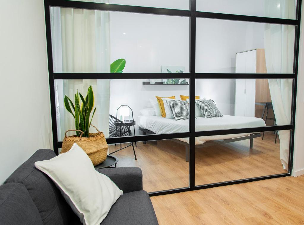 a living room with a couch and a large window at Edificio Bel in Benicarló