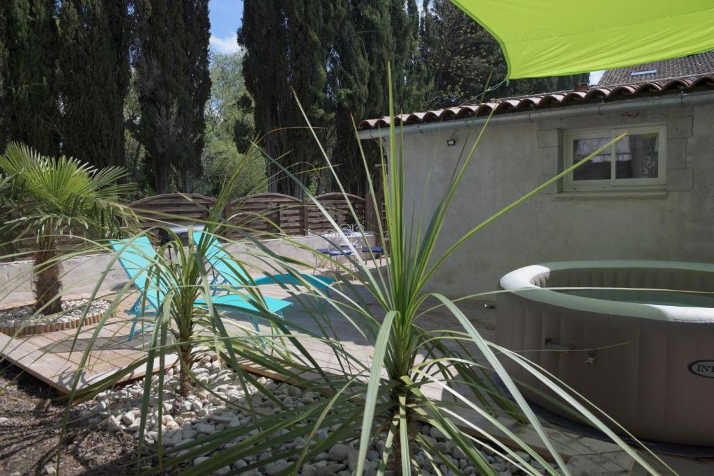 a backyard with a swimming pool and a green umbrella at Gite L'Acacia in Lagorce