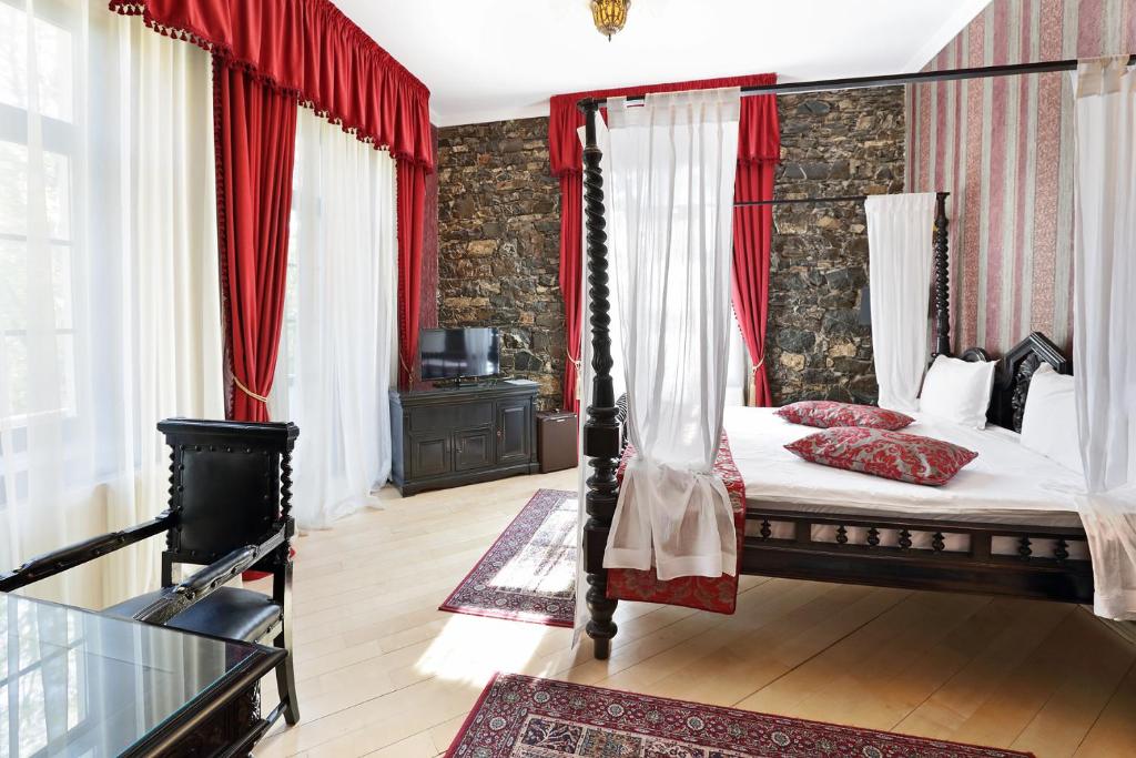 a bedroom with a canopy bed and red curtains at Regal 1880 in Sinaia