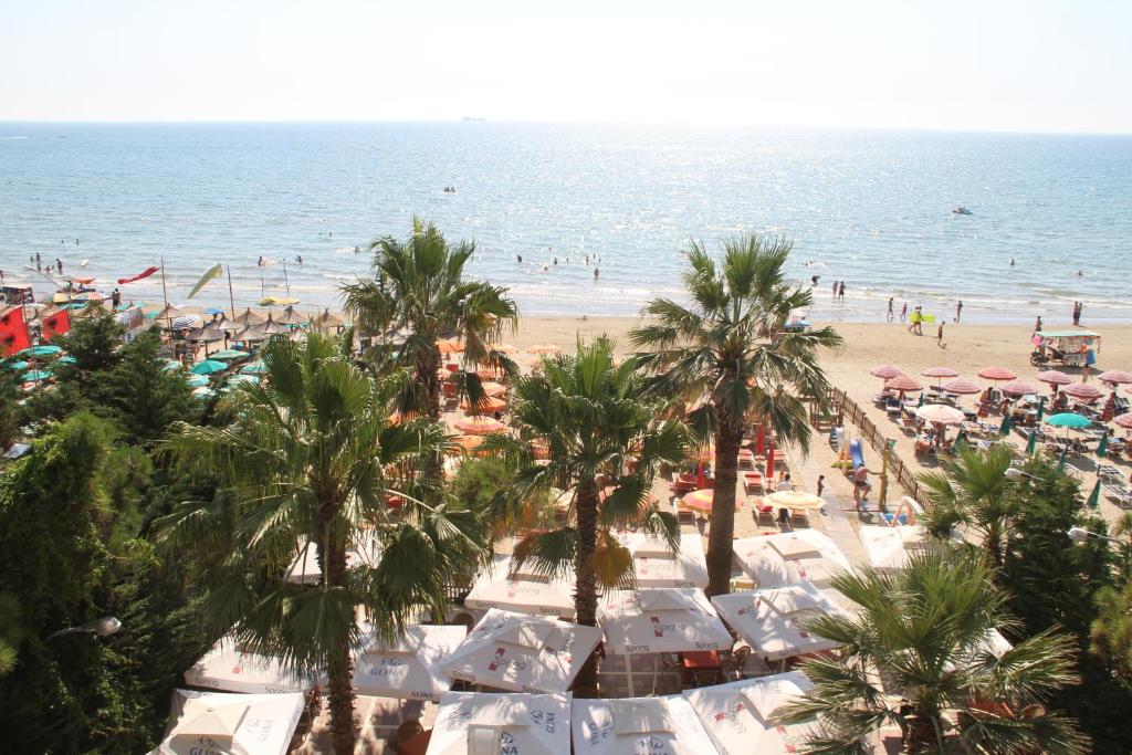 una playa con palmeras y multitud de personas en Hotel Adriatik 2, en Durrës