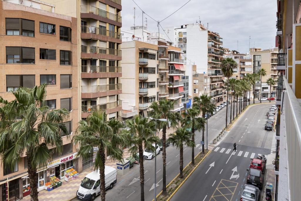 a city street with palm trees and buildings at La Ponderosa, 4º-21 in Cullera