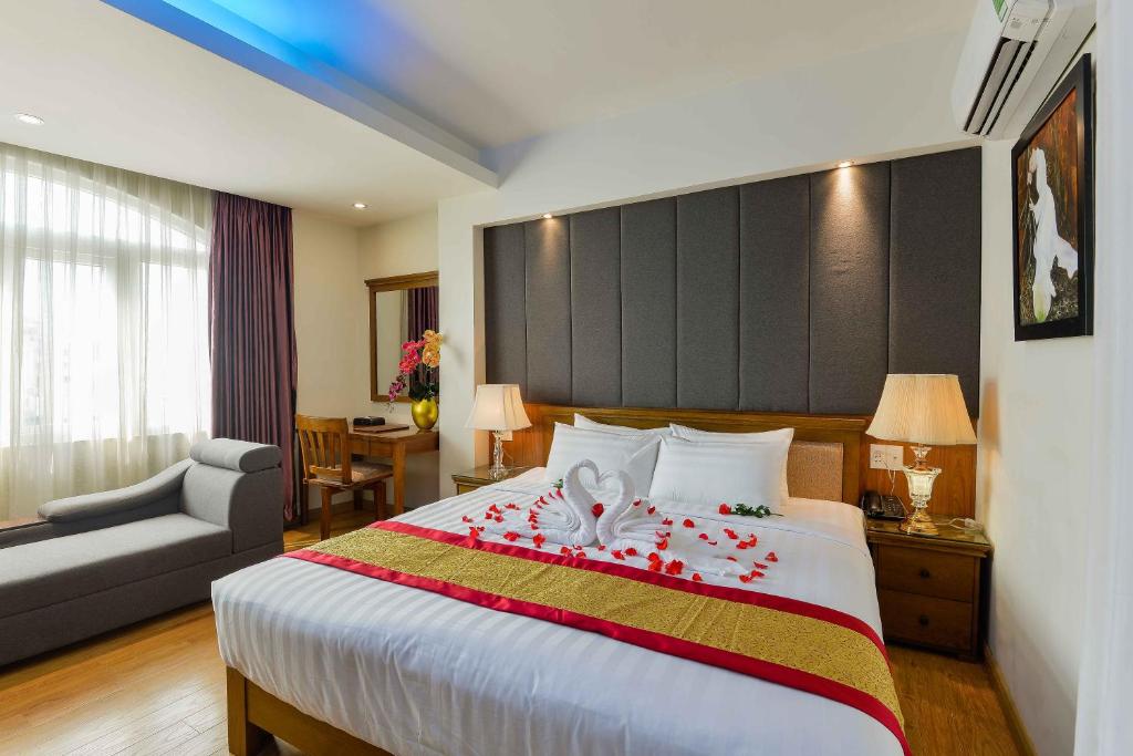 Saigonciti Hotel A في مدينة هوشي منه: غرفة في الفندق سرير كبير عليه ورد