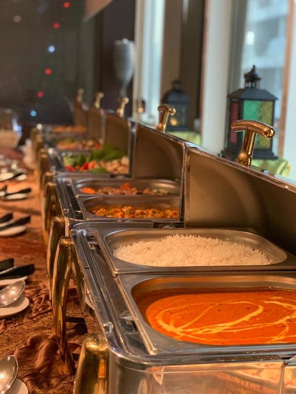 a row of trays filled with food on a table at Hala Inn Hotel Apartments - BAITHANS in Ajman 