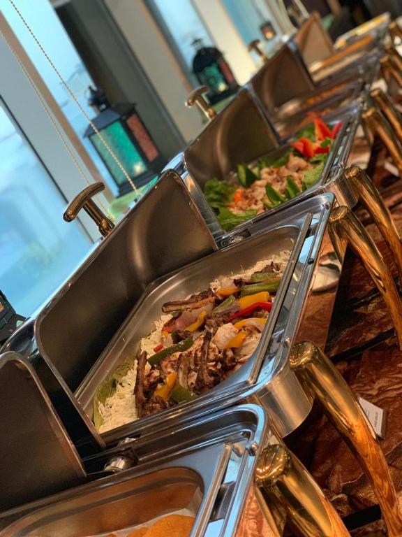 three trays of food sitting on top of a table at Hala Inn Hotel Apartments - BAITHANS in Ajman 