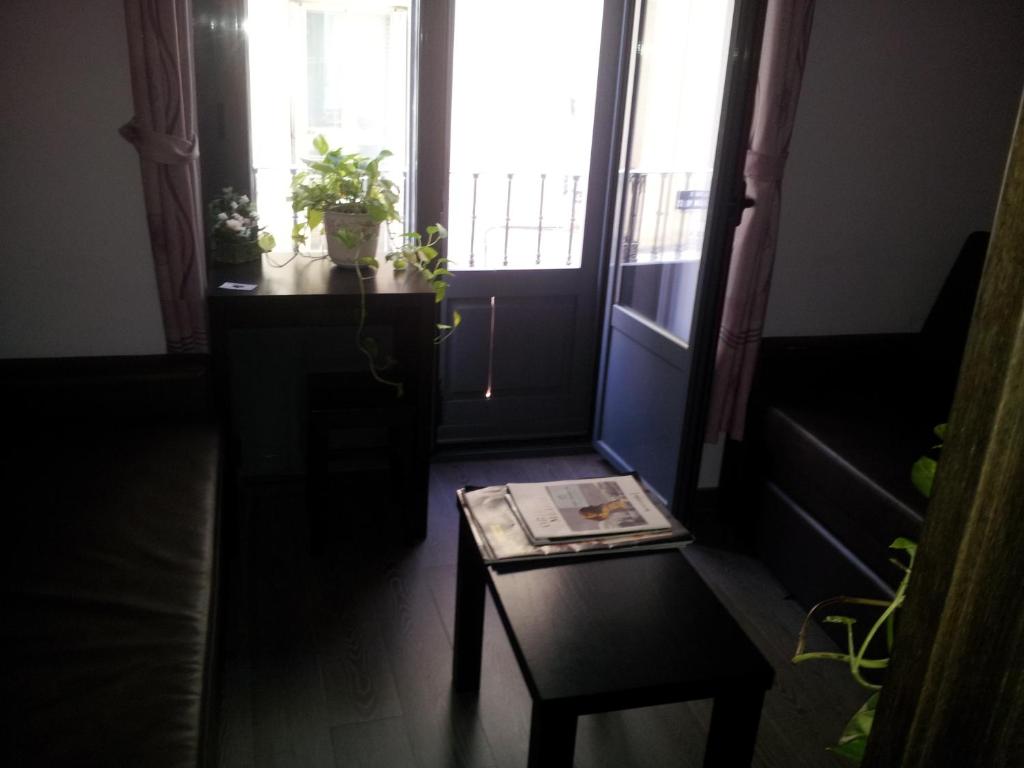 Habitación con mesa, silla y 2 ventanas en Hostal Corazón de Madrid, en Madrid