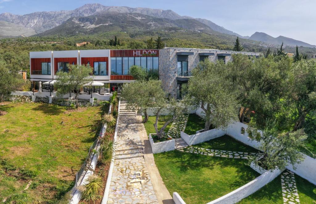an aerial view of a building with mountains in the background at Hildon Eco Hotel in Dhërmi