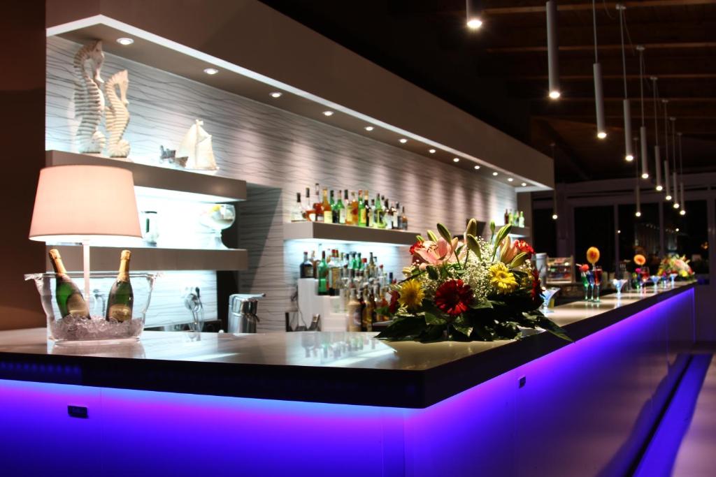 bar z blatem z kwiatami i butelkami wina w obiekcie Hotel Torre Oliva w mieście Policastro Bussentino