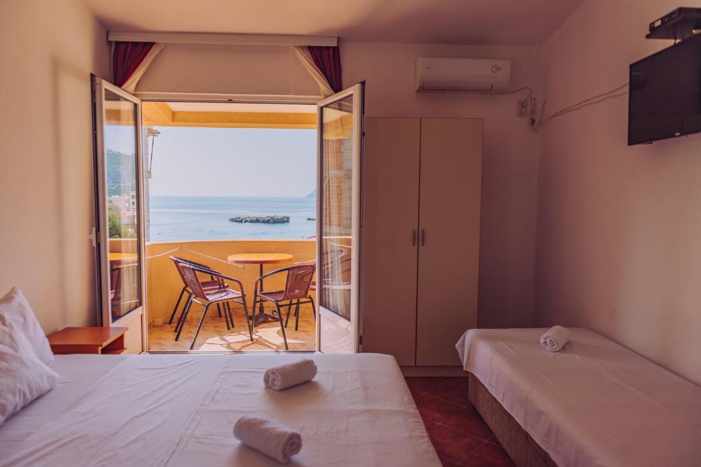 a room with two beds and a view of the ocean at Apartmani Lasta in Dobra Voda