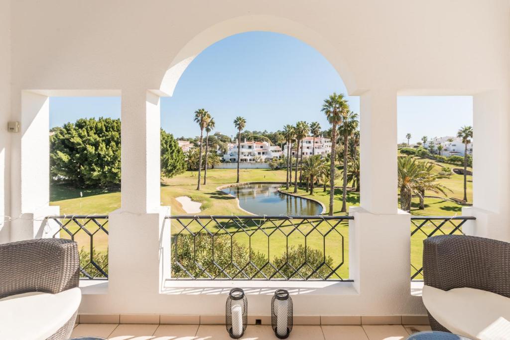 um quarto com vista para uma piscina e palmeiras em Casa Folkiño em Carvoeiro