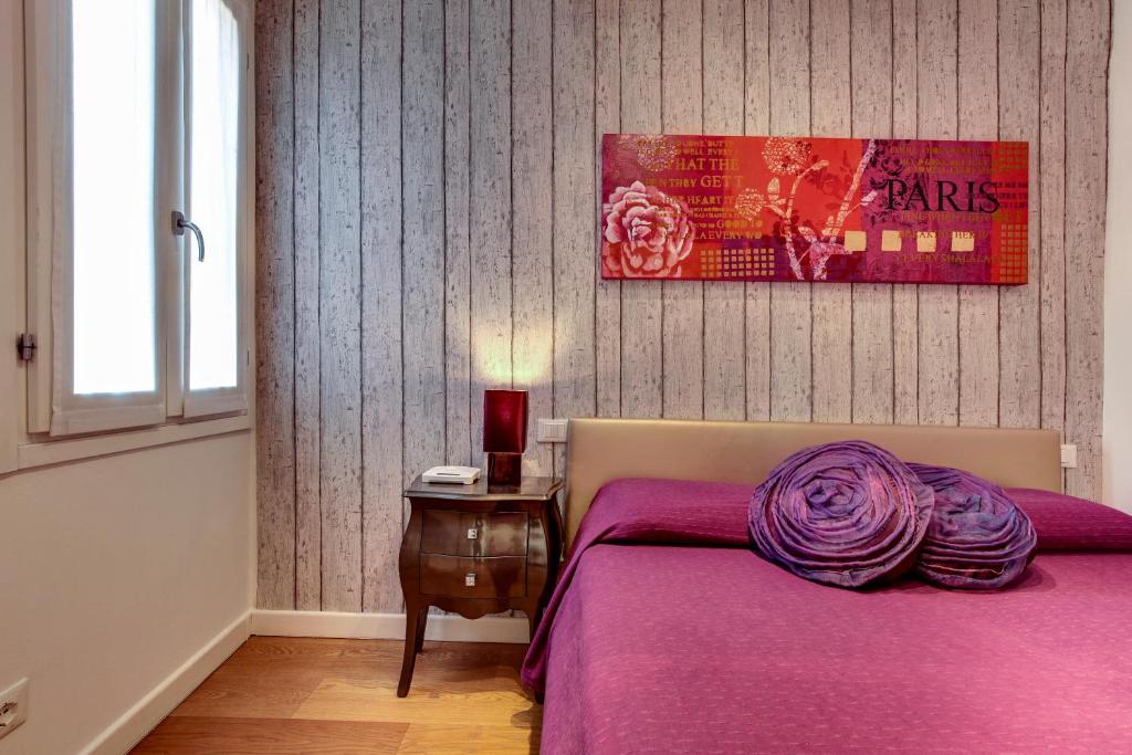 a bedroom with a bed with a purple blanket on it at Ca' d'Oro Design in Venice