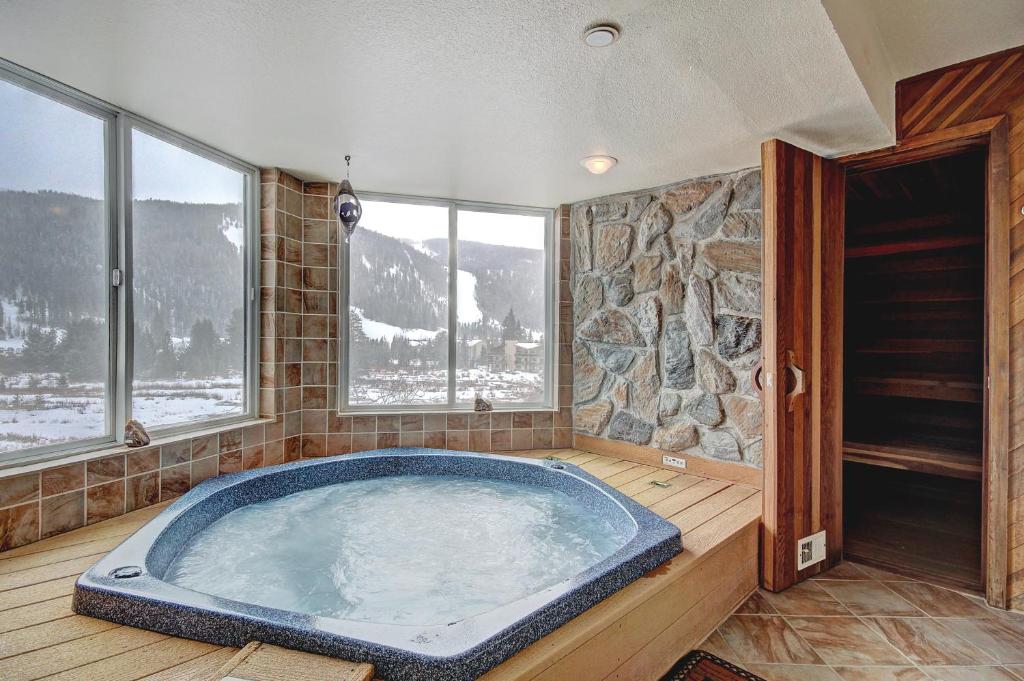 a jacuzzi tub in a room with windows at Cri221 Cinnamon Ridge Condo in Keystone
