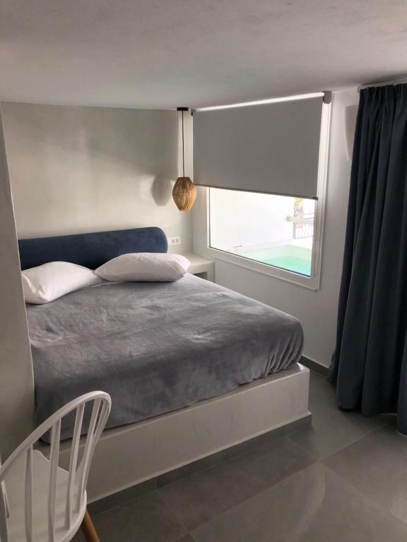 a bedroom with a bed and a large window at Galatia Villas in Fira