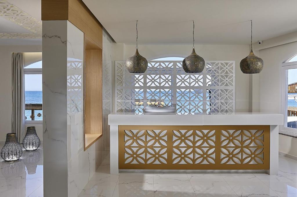 a kitchen with two pendant lights and a counter at Vasia Boulevard Hotel (Adults Only) in Hersonissos